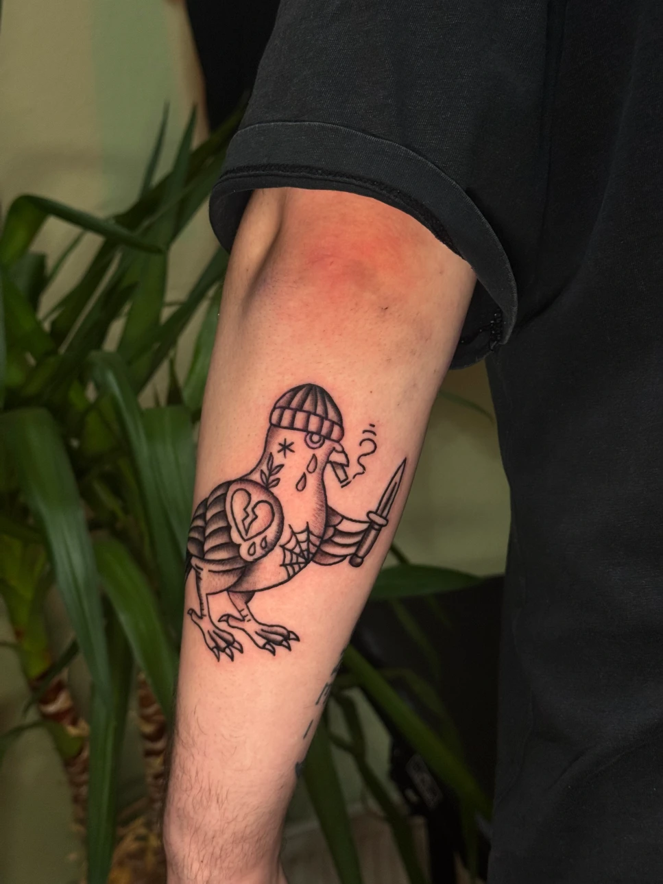 Oldschool tattoo of a stylized bird with clean lines - Traditional tattoo on the forearm in Munich